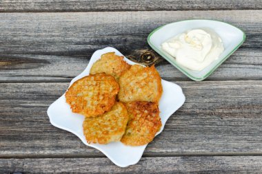 Tabak patates gözlemesi ve ekşi krema ile. Gri ahşap arka plan