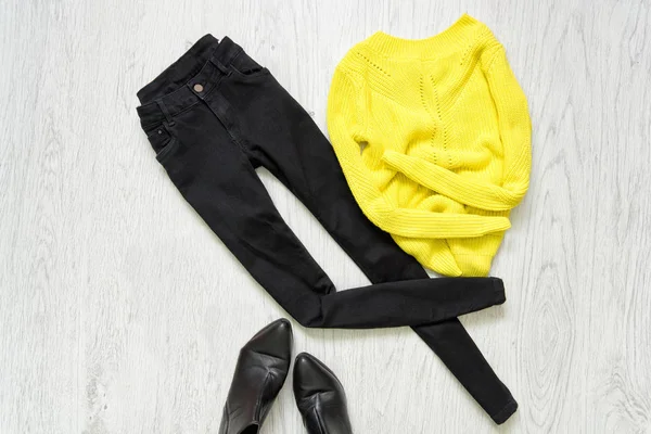 Jeans neri, maglione giallo e scarpe nere su fondo di legno — Foto Stock