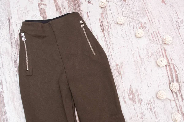 Braune Hose mit Reißverschlüssen auf Holzgrund — Stockfoto