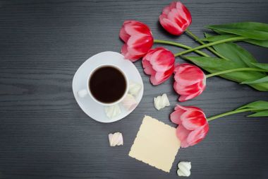 Bir fincan kahve, lokum, boş kartpostal ve Pembe Lale üzerinde Üstten Görünüm