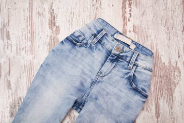 Ahşap zemin üzerine mavi jeans. Moda kavramı