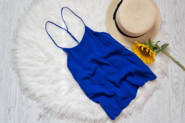 Mavi t-shirt. Şapka ve ayçiçeği beyaz kürk üzerinde. Moda kavramı