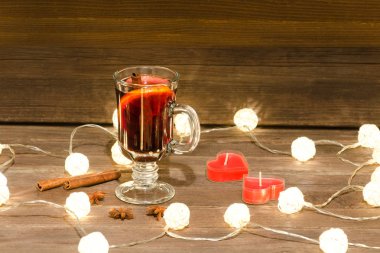 Kupa ile baharat, mumlar ve fenerler ahşap bir masa üzerinde mulled şarap