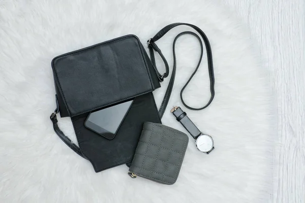 Açık bırakılan cep telefonu, saat ve çanta ile siyah çanta. Kürk — Stok fotoğraf