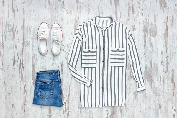White and blue striped shirt, white sneakers and jeans. Fashionable concept