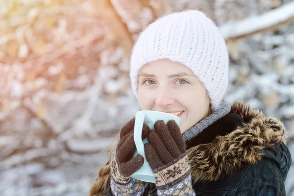 Dziewczyna w zimowe ubrania, pić herbatę z kubka. Widok z boku. zbliżenie — Zdjęcie stockowe