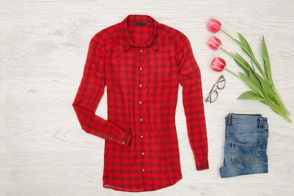 Conceito de moda. Blusa vermelha, jeans, batom e tulipas rosa — Fotografia de Stock