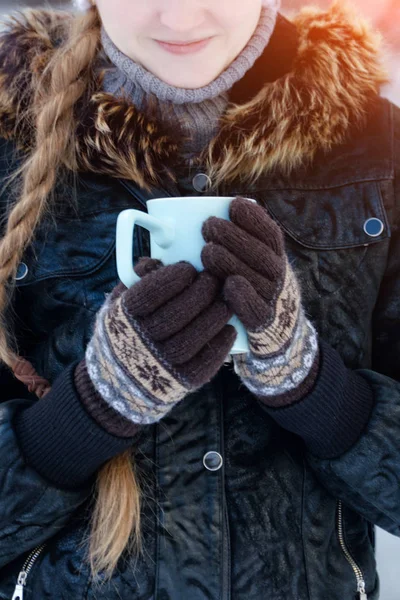 Dziewczyna w rękawiczkach brązowy gospodarstwa niebieski kubek herbaty, części twarzy — Zdjęcie stockowe