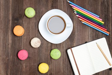 Kahve kupa, bademli kurabiye, renkli kalemler ve dizüstü