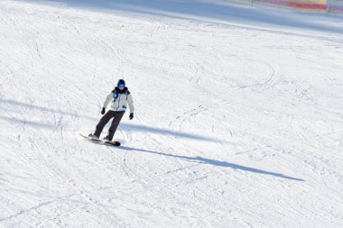 Bukovel, Ukrayna-27 Ocak 2018: adam gözlük ve bir takım elbise bir snowboard binme. Karla kaplı yamaç