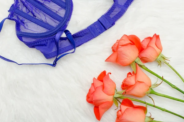 Part of violet lace bodice on fur and orange roses — Stock Photo, Image