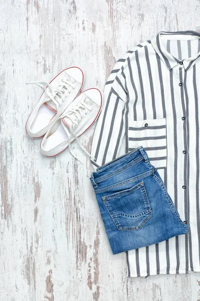 Біло-блакитна смугаста сорочка, білі кросівки та джинси — стокове фото