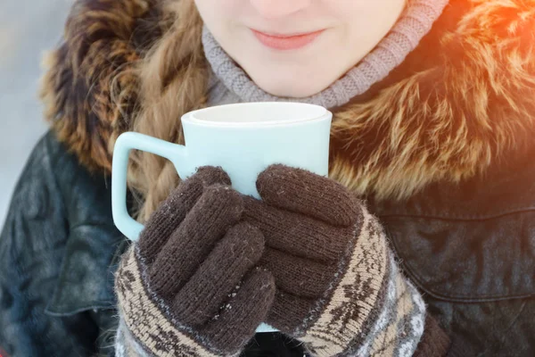 Chica en los guantes marrones sosteniendo una taza de té azul —  Fotos de Stock