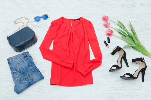 Modekonzept. rote Bluse, Schuhe, Jeans, Handtasche und rosa Tulpen. Ansicht von oben — Stockfoto