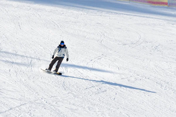 A Bukovel, Ukrajna-27 január 2018: férfi szemüveg és egy öltönyt, lovaglás snowboard. Hó-lejtőn — Stock Fotó