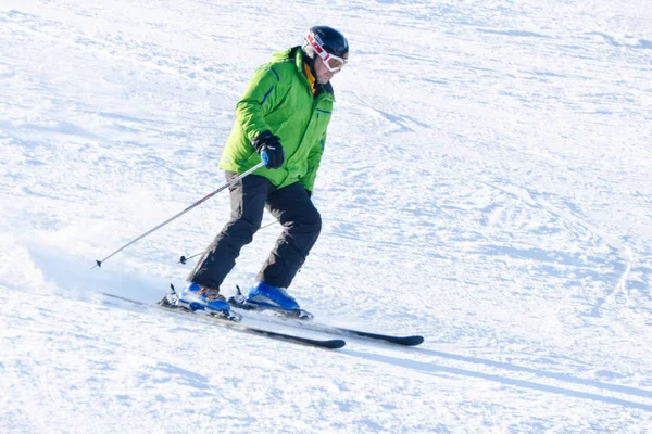 En äldre man skidåkning ner snöiga backen — Stockfoto