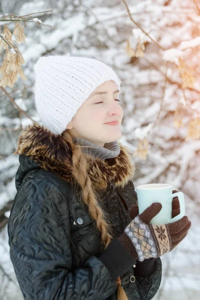 Chica sonriente con taza de té disfrutando del sol. Invierno, al aire libre —  Fotos de Stock