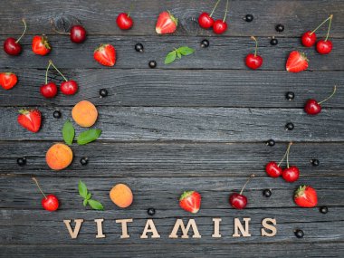 Yazıt vitamin ve meyve. Siyah ahşap arka plan