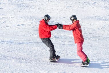 Bukovel, Ukrayna-27 Ocak 2018: Eğitmen dersi snowboard binmek için bir adam. Güneşli gün