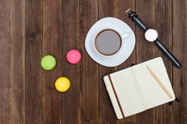 Üstten Görünüm Kupası kahve, macarons, defter ve izle