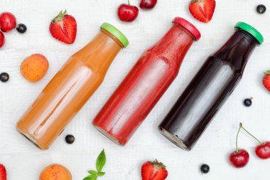 Üç şişe suyu, meyve Beyaz ahşap zemin üzerinde