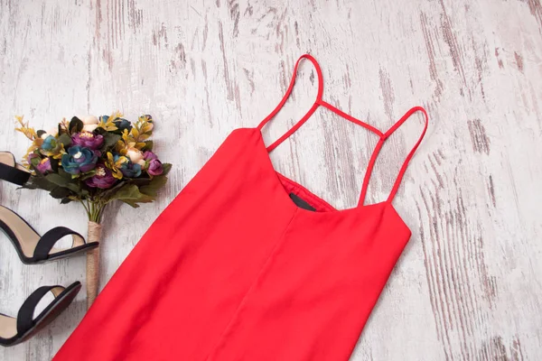 Red dress, shoes and a bouquet of flowers. Fashionable concept