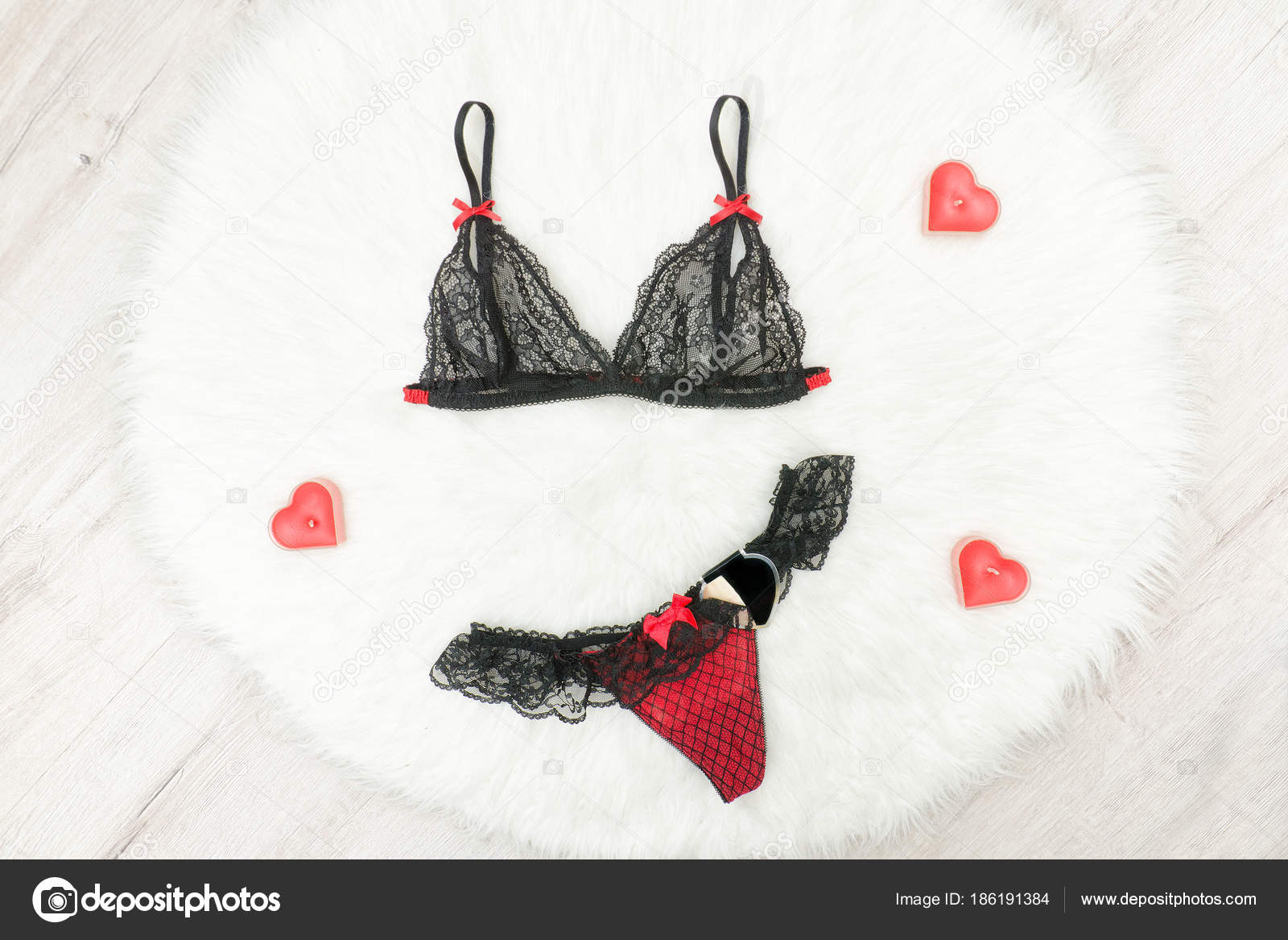 Fashion concept. Black lacy bra and panties on white fur Stock