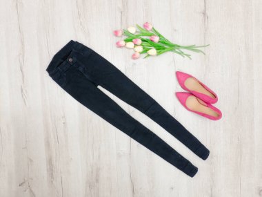 Moda kavramı. Siyah kot pantolon, pembe Ayakkabı ve Lale. Üstten Görünüm
