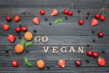 Yazıt vegan ve meyve. Siyah ahşap arka plan