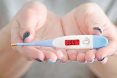 Bir erkek olarak elektronik termometre eller. Yüksek vücut sıcaklığı