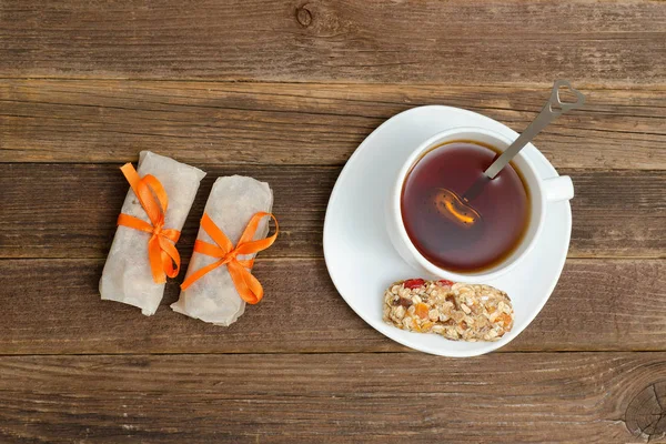 Draufsicht auf Tasse Tee und ein paar Tafeln Müsli. brauner Holzhintergrund — Stockfoto