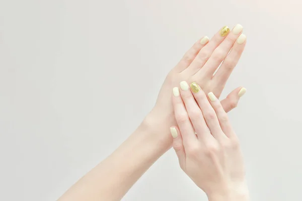 Krásné ženské ruce s manikúrou na světlém pozadí — Stock fotografie