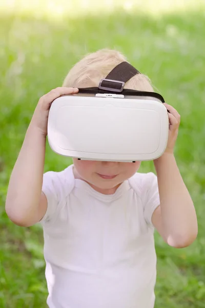 Маленький хлопчик у шоломі віртуальної реальності на фоні — стокове фото