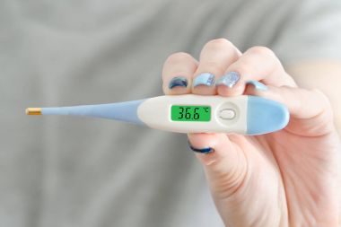 Elektronik termometre içinde bir el. Normal sıcaklık