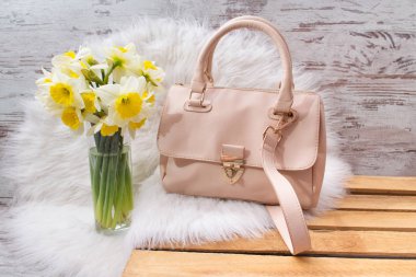 Pembe hahdbag ve Nergis beyaz kürk üzerinde buket. Moda kavramı