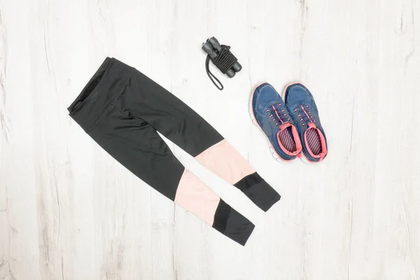 Sports breeches, sneakers and jump rope. Fashionable sports concept