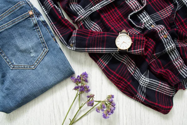 Del av rutiga skjortor, klockor, jeans och blommor — Stockfoto