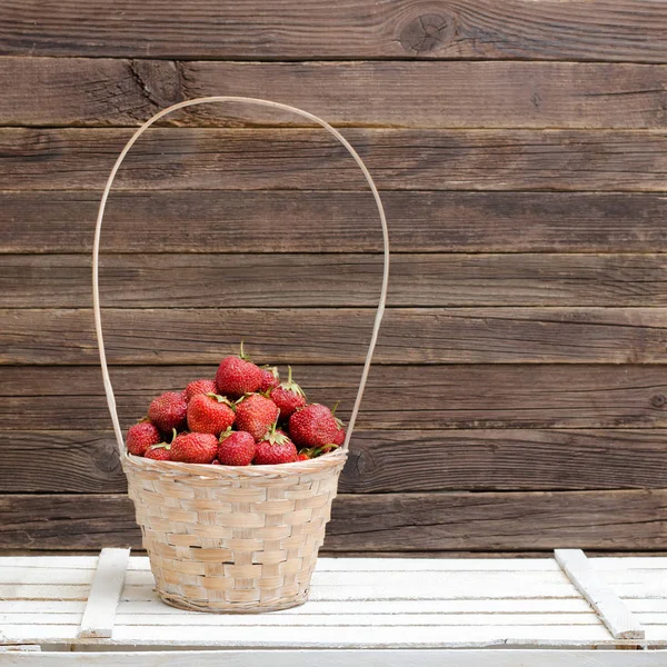 Cesta de fresas maduras sobre fondo de madera. Espacio para texto — Foto de Stock