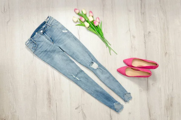 Blaue zerlumpte Jeans und ein Strauß Tulpen. Modisches Konzept — Stockfoto