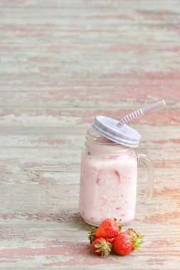 Kupa yoğurt ve çilek kırmızı arka plan vintage ahşap plakalar üzerinde