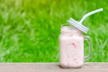 Bir fincan yeşil çim zemin üzerine yoğurt. Metin için yer