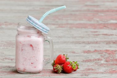 Kupa yoğurt ve çilek kırmızı arka plan vintage ahşap plakalar üzerinde