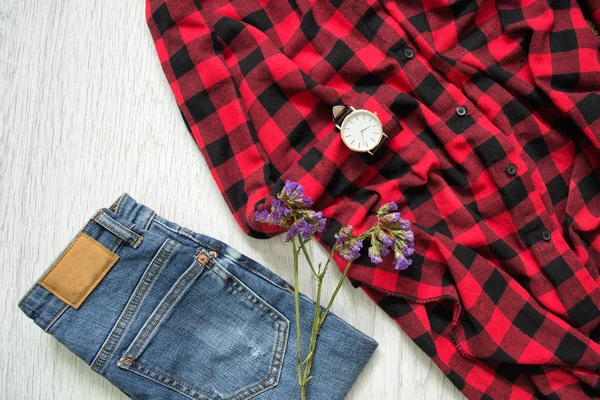 Blå jeans, rutig skjorta, klockor och blomma. Trä bakgrund — Stockfoto