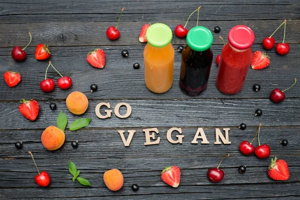 Üç şişe suyu, meyve ve yazıt Go vegan.