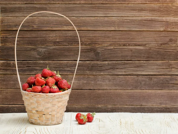 Cesta de fresas maduras sobre fondo de madera. Espacio para texto — Foto de Stock
