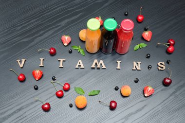 Üç şişe suyu, yazıt vitaminler ve meyve.