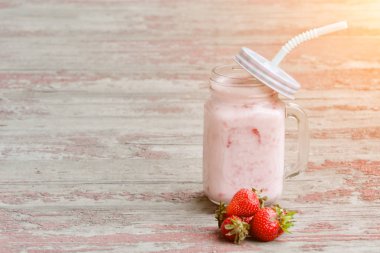 Kupa yoğurt ve çilek kırmızı arka plan vintage ahşap plakalar üzerinde