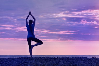 Sahil, gün batımı pratik yoga kıza arkadan görünüm