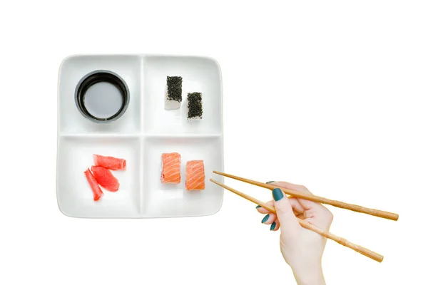 Female hand with chopsticks and plate with sushi — Stock Photo, Image