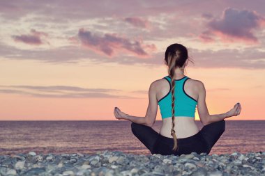 Lotus pozisyonu Sahilde meditasyon kadın. Günbatımı.